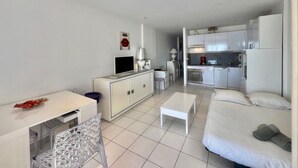 Un appartement moderne comprenant un coin repas, un salon et une kitchenette.