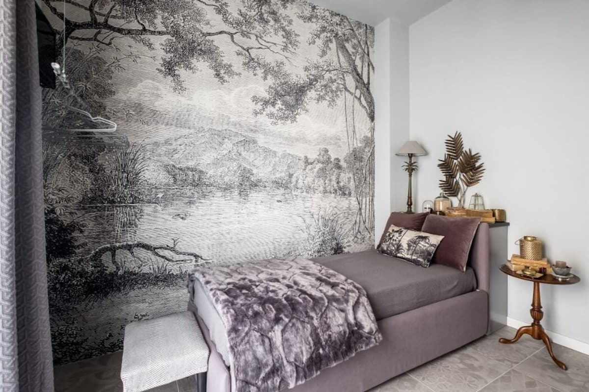 Un dormitorio moderno con una cama grande, una mesita de noche y un tapiz en la pared.
