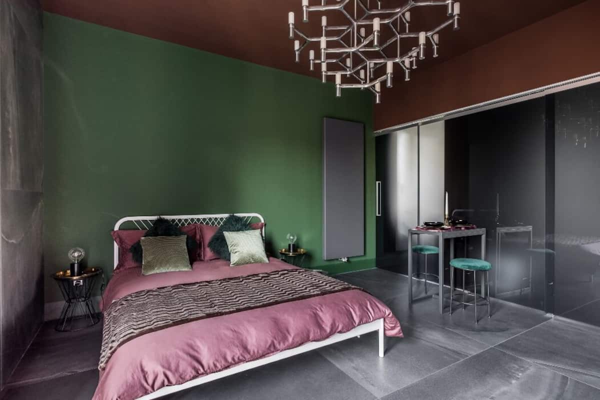 Un dormitorio moderno con cama, mesita de noche y una silla.