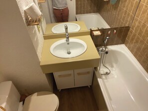 Une salle de bain avec deux lavabos, une baignoire et des toilettes.