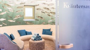 A spa room with a curved sofa, a small window, and a wall decorated with fish patterns. - Landhaus Christl am See (Bad Wiessee)