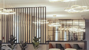 A modern lobby with tiered seating, pendant lighting, and potted plants. - Hotel Fero Express (Kraków)