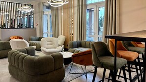 A modern living room with a sectional sofa, a coffee table, and a bar area with stools. - Hotel Fero Express (Kraków)