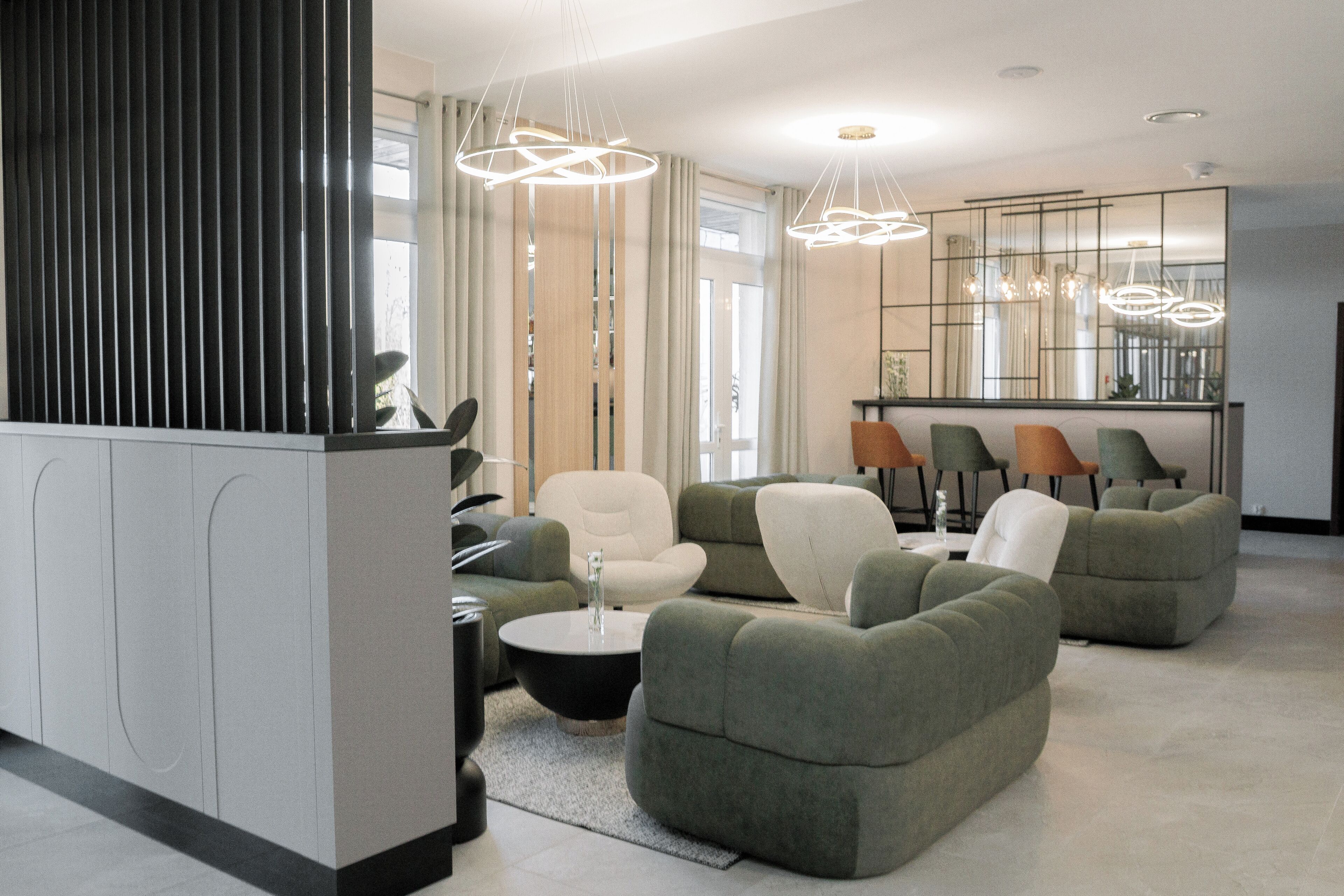 Un salon moderne avec un ensemble de canapés, une table basse et des luminaires suspendus.