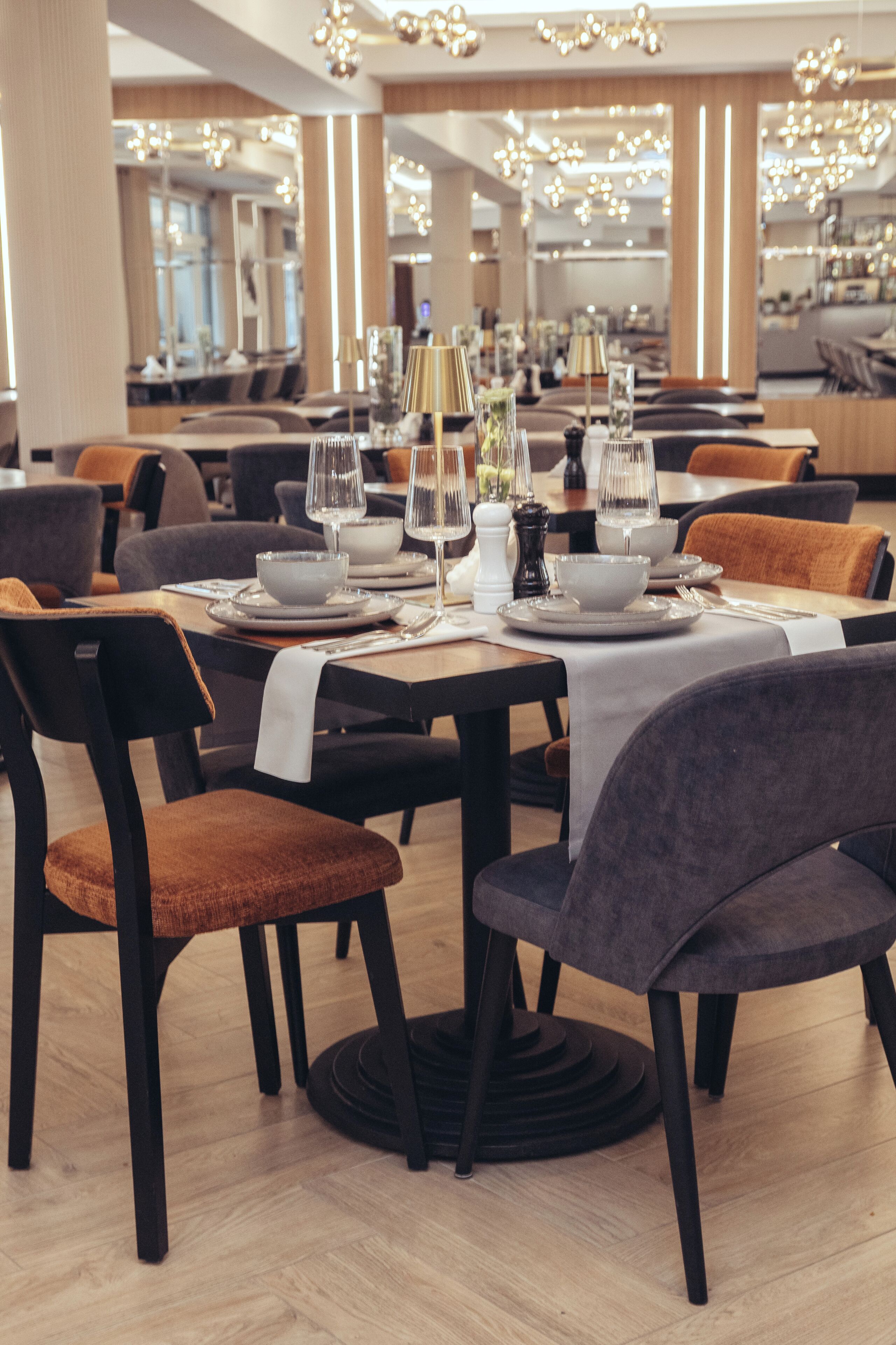 Un restaurante con mesas dispuestas para comer, sillas y un diseño de interiores moderno.