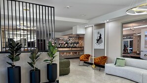 A modern interior with a bar area, seating, and decorative plants. - Hotel Fero Express (Kraków)