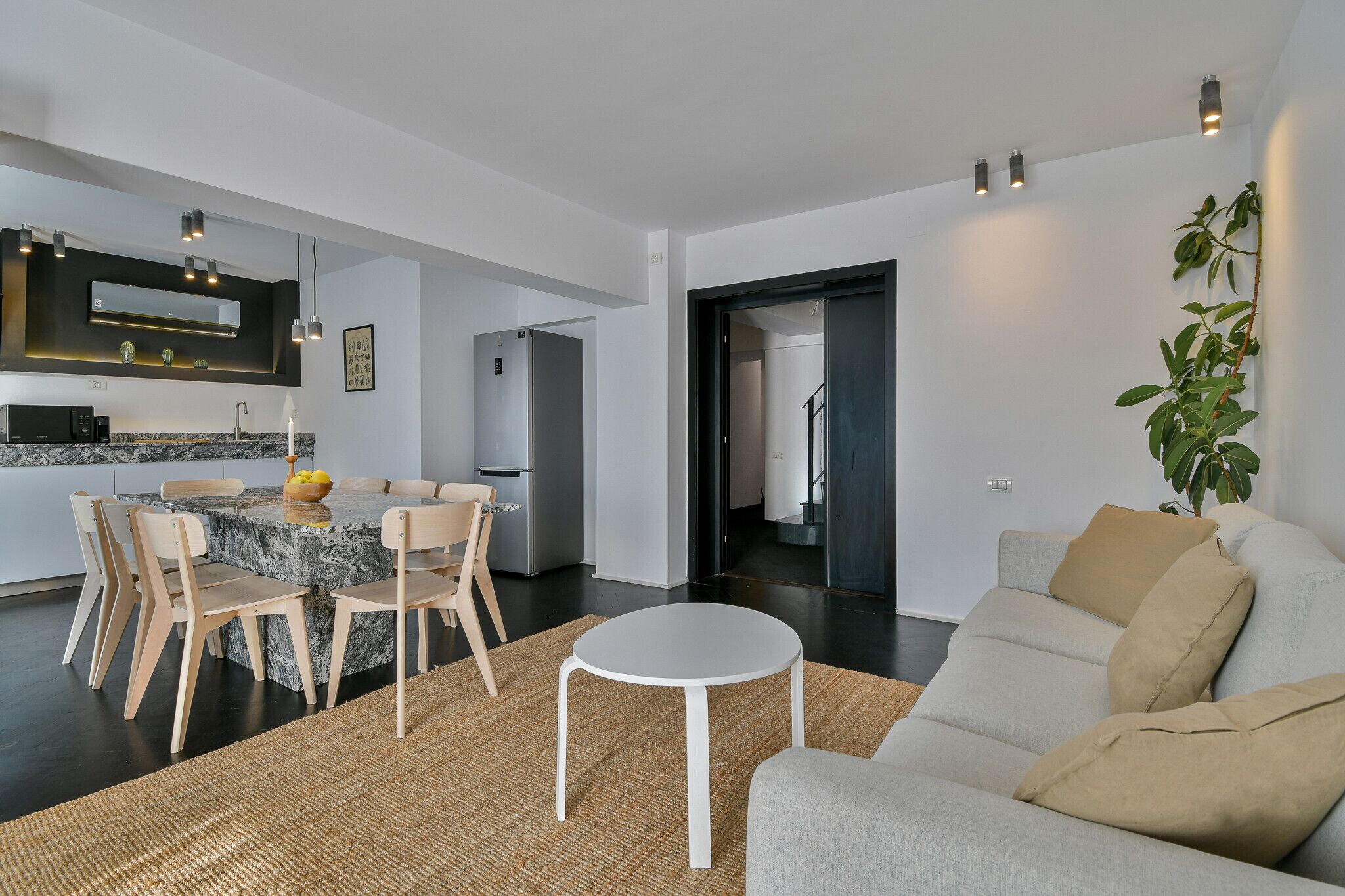 A modern living space with a kitchen, dining area, and seating area.