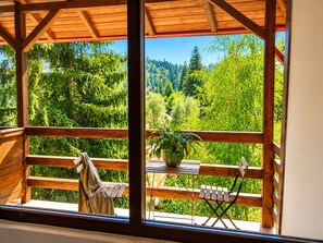 A wooden balcony with a view of a forested landscape. - Forest Apartment by Olala Homes (Sinaia)