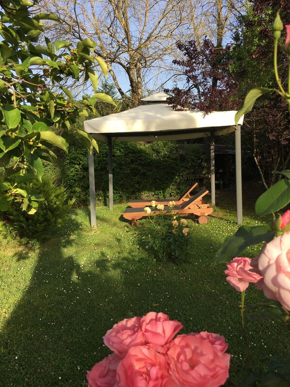A garden with a gazebo, a wooden bench, and blooming flowers. - Villa del Lago (Barberino di Mugello)