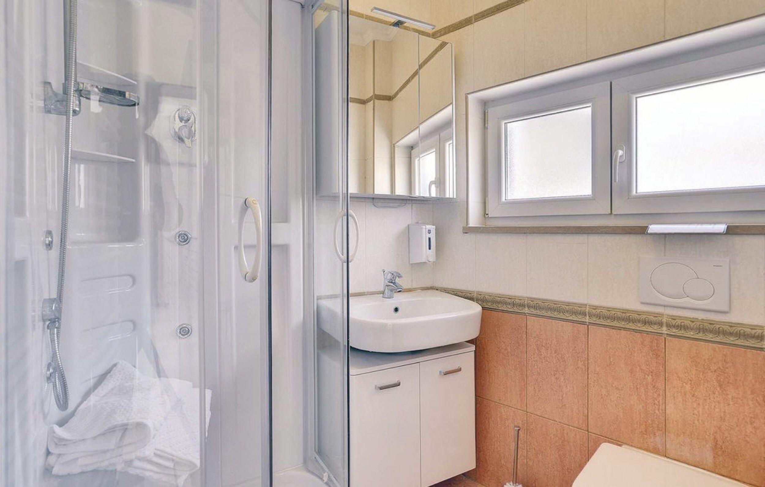 Une salle de bain avec une douche à parois de verre, un lavabo et un miroir au-dessus.