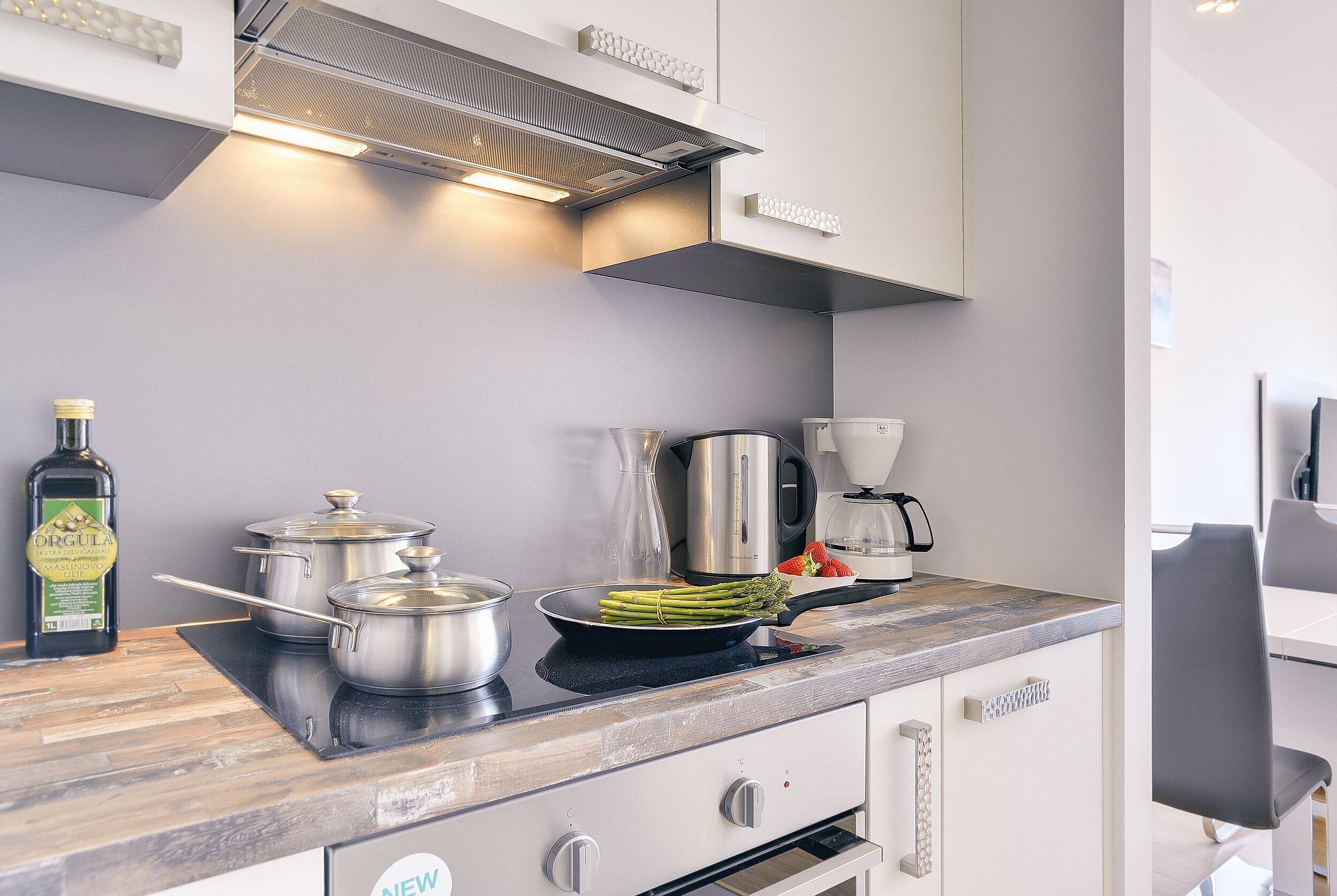 A modern kitchen with stainless steel appliances, a built-in oven, and a coffee maker.