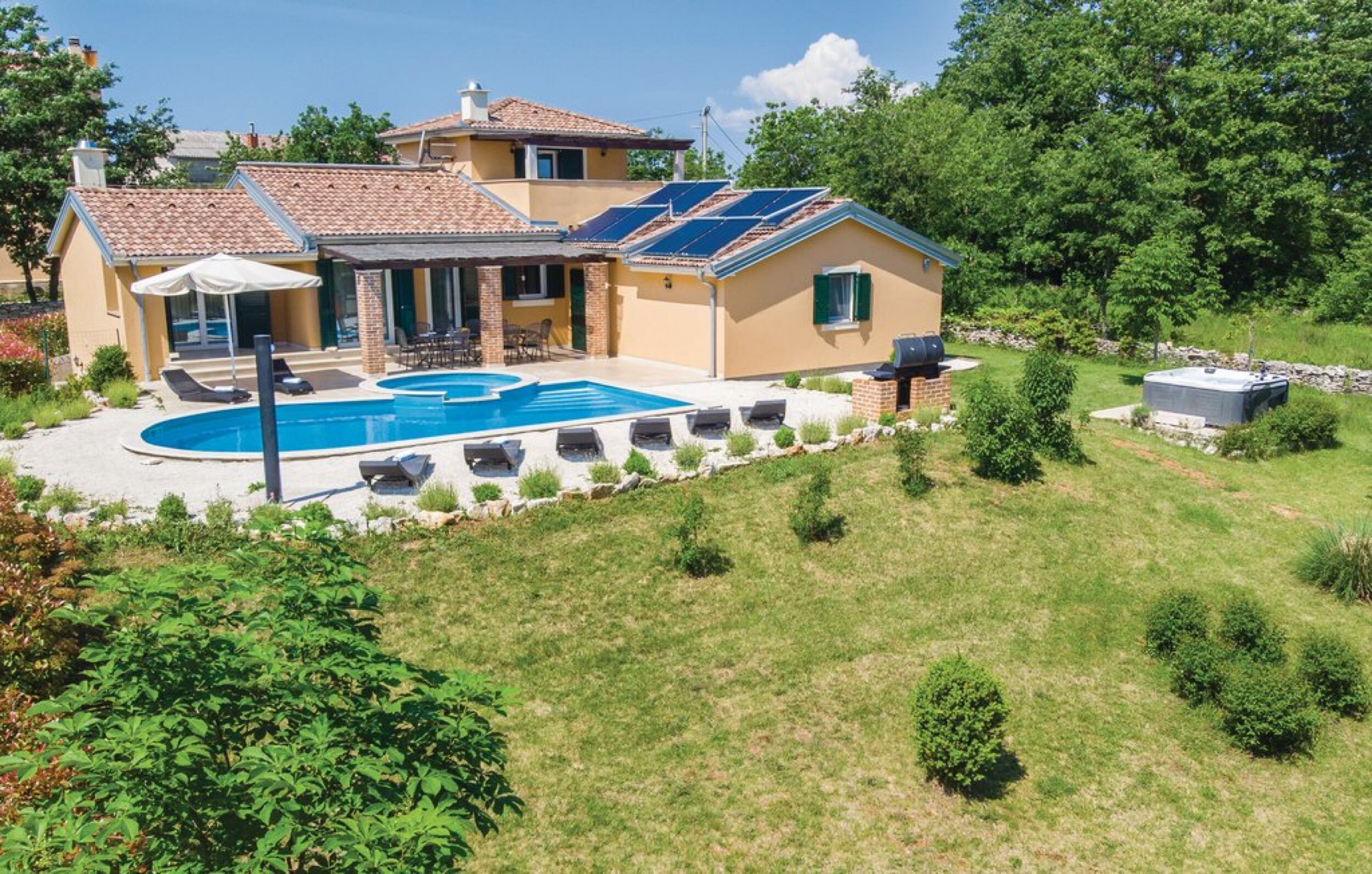 Una casa con piscina, paneles solares y jardín.