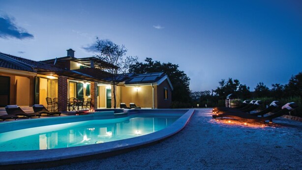 Ein modernes Haus mit Swimmingpool, Außenbereich und Solaranlage.