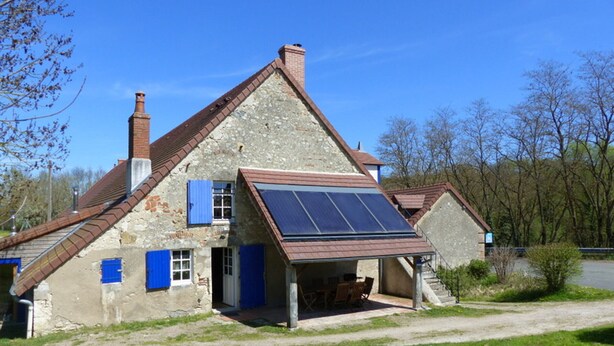 A rustic stone house with a sloped roof, a chimney, and a solar panel on the roof. - Renovated eco-lodge with wifi near Vichy (Bransat)