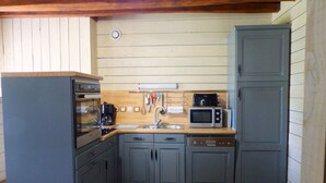 A compact kitchen with grey cabinets, a microwave, a coffee maker, and a sink. - Renovated eco-lodge with wifi near Vichy (Bransat)