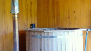 A wooden interior with a hot tub and a metal pipe. - Renovated eco-lodge with wifi near Vichy (Bransat)