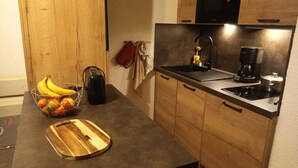 A kitchen with a wooden countertop, a sink, a coffee maker, and a cutting board. - Appartement Plein Centre du Chinaillon (Le Grand-Bornand)