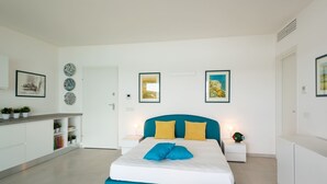 A modern bedroom with a bed, bedside tables, a nightstand, and a white wardrobe. - AIRONI - AIRONI 8 MONO (Golfo Aranci)