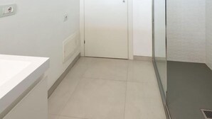 A bathroom with a white sink, a door, and a glass shower enclosure. - AIRONI - AIRONI 8 MONO (Golfo Aranci)