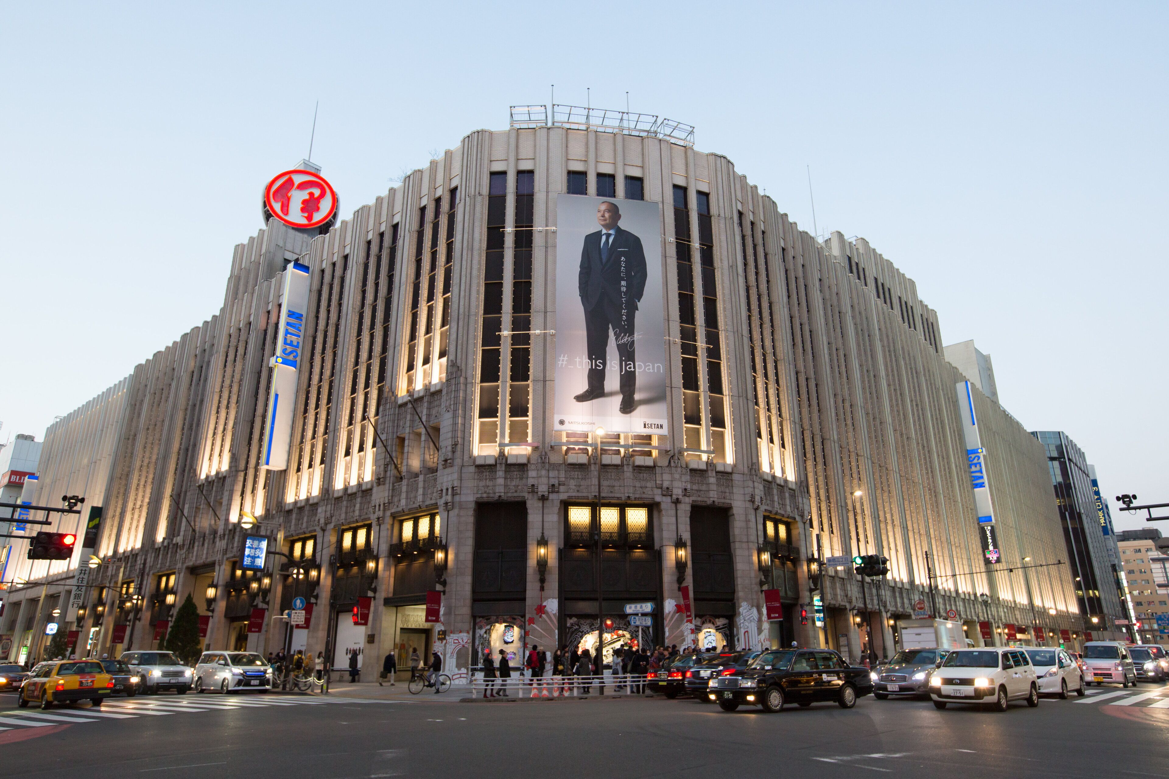 A large building with a prominent billboard featuring a man in a suit.