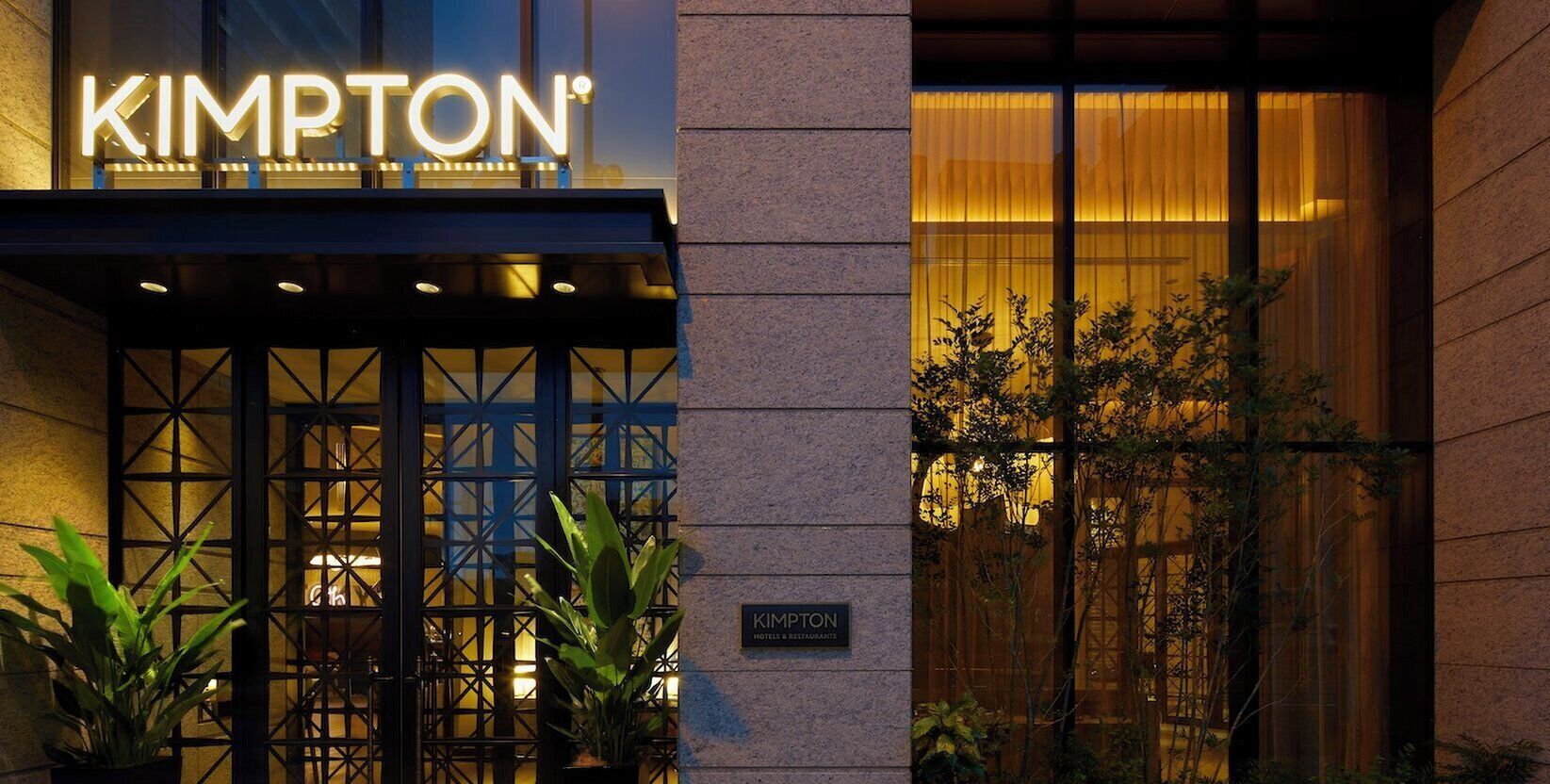 The exterior of a hotel with a prominent sign reading 'KIMPTON HOTEL RESTAURANT'.