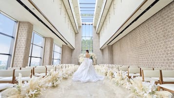 A wedding ceremony aisle with floral decorations and chairs.