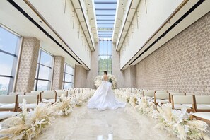 A wedding ceremony aisle with floral decorations and chairs.