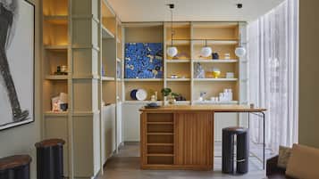 A modern kitchen with open shelving, a central island, and a dining area.