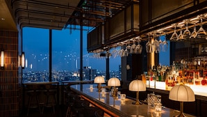 A bar area with a city view, bar stools, and a variety of bottles. - Kimpton Shinjuku Tokyo by IHG (Tokyo)