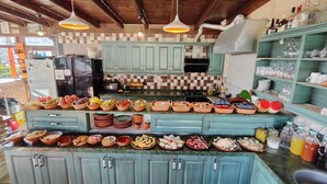 A kitchen with teal cabinets, a tiled backsplash, and various food items displayed on the counter. - Vintage Cave House (Nevsehir)