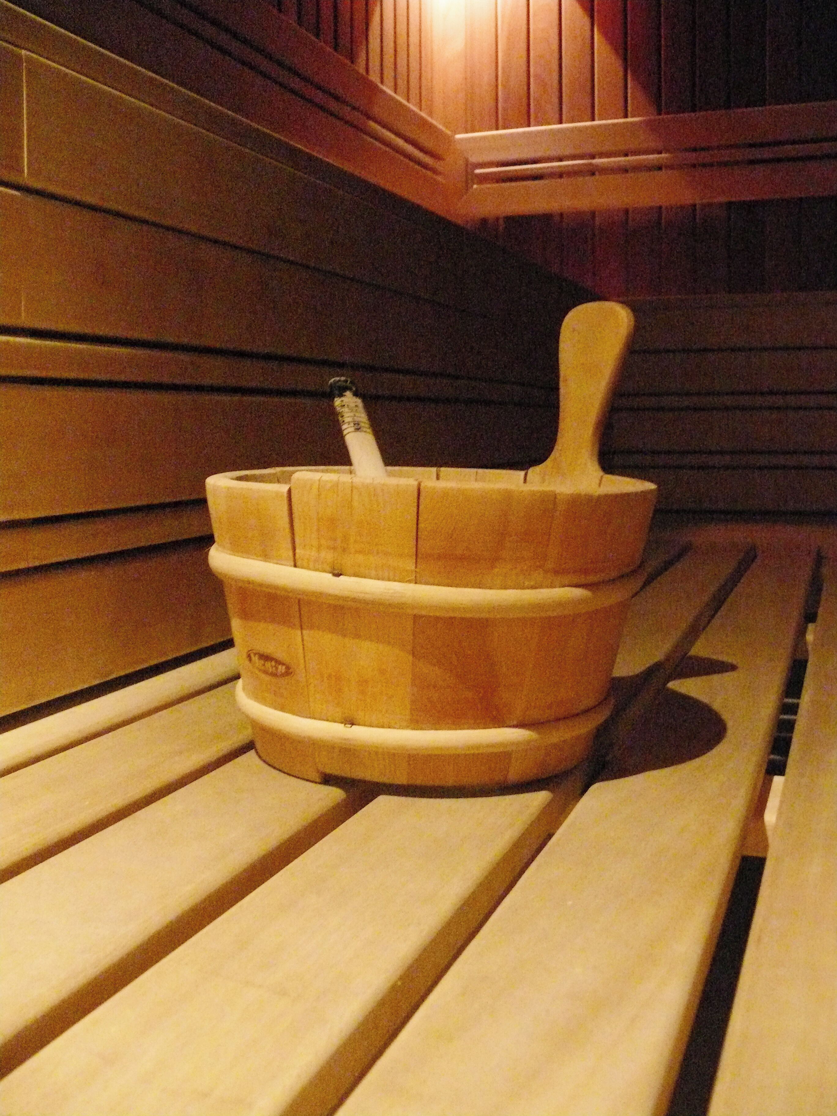 A wooden bench with a wooden bucket and a wooden mallet.