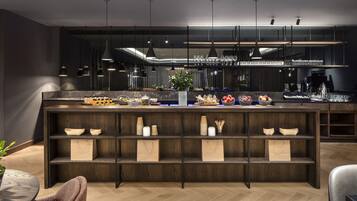Une cuisine moderne avec des étagères en bois foncé, un plan de travail en marbre et des luminaires suspendus.