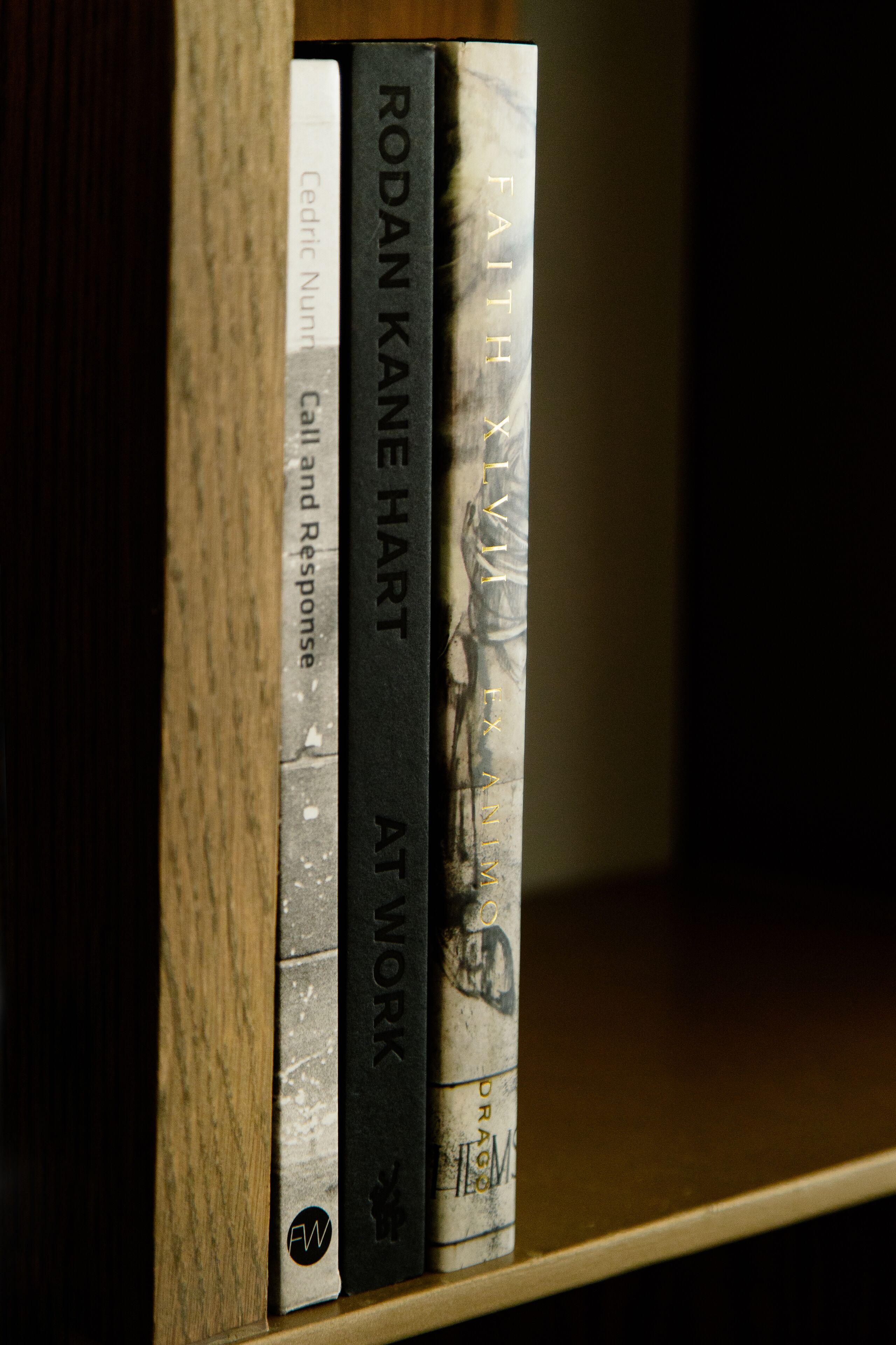 Kirjahylly, jossa on kirjoja, joiden nimet ovat ’Call and Response’, ’At Work’ ja ’Faith’.