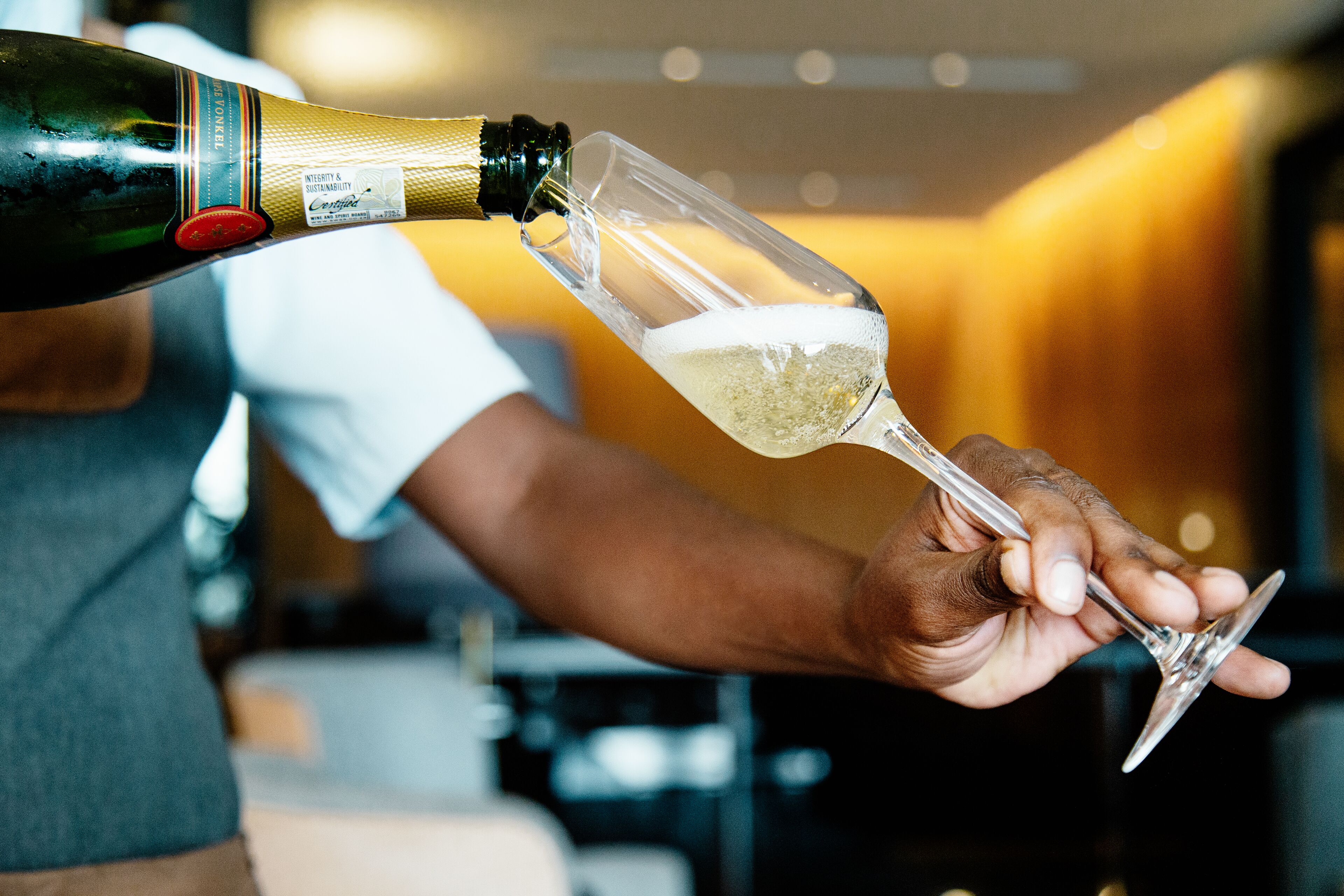 Une personne qui verse du champagne dans un verre.