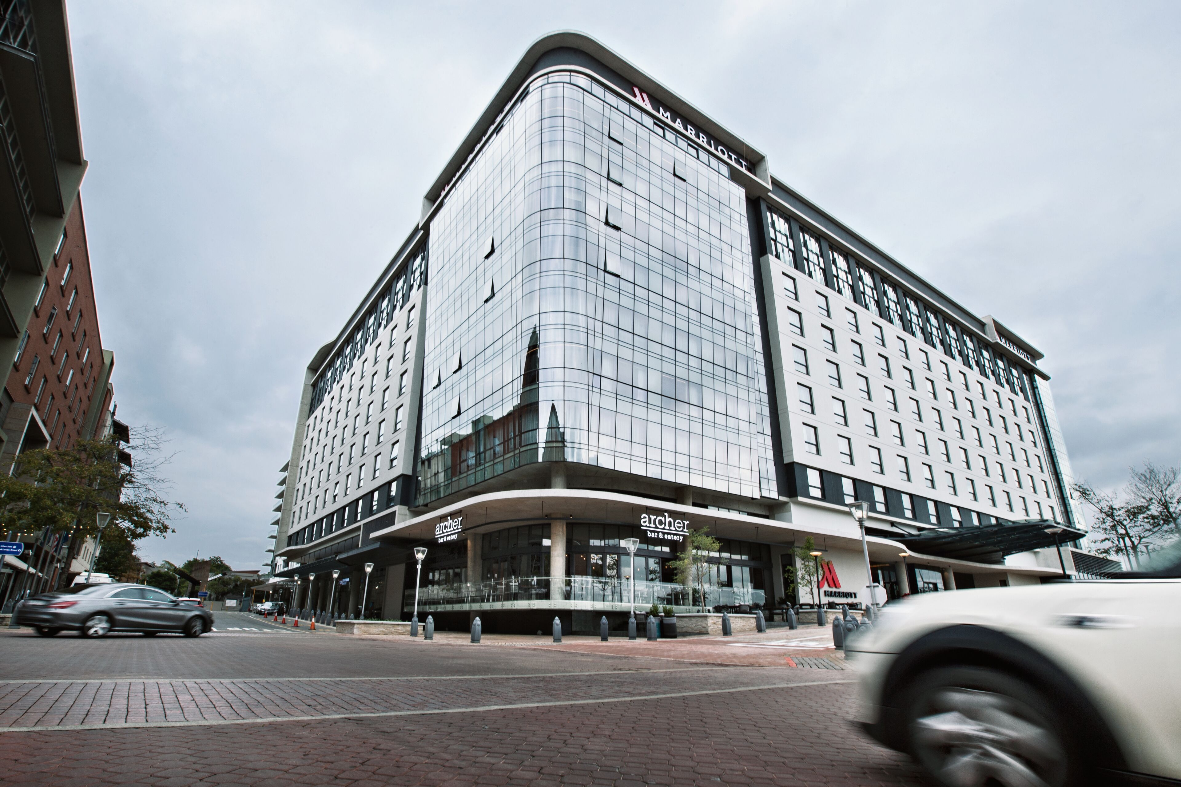 A modern hotel with a curved facade, large windows, and a prominent 'Marriott' sign.