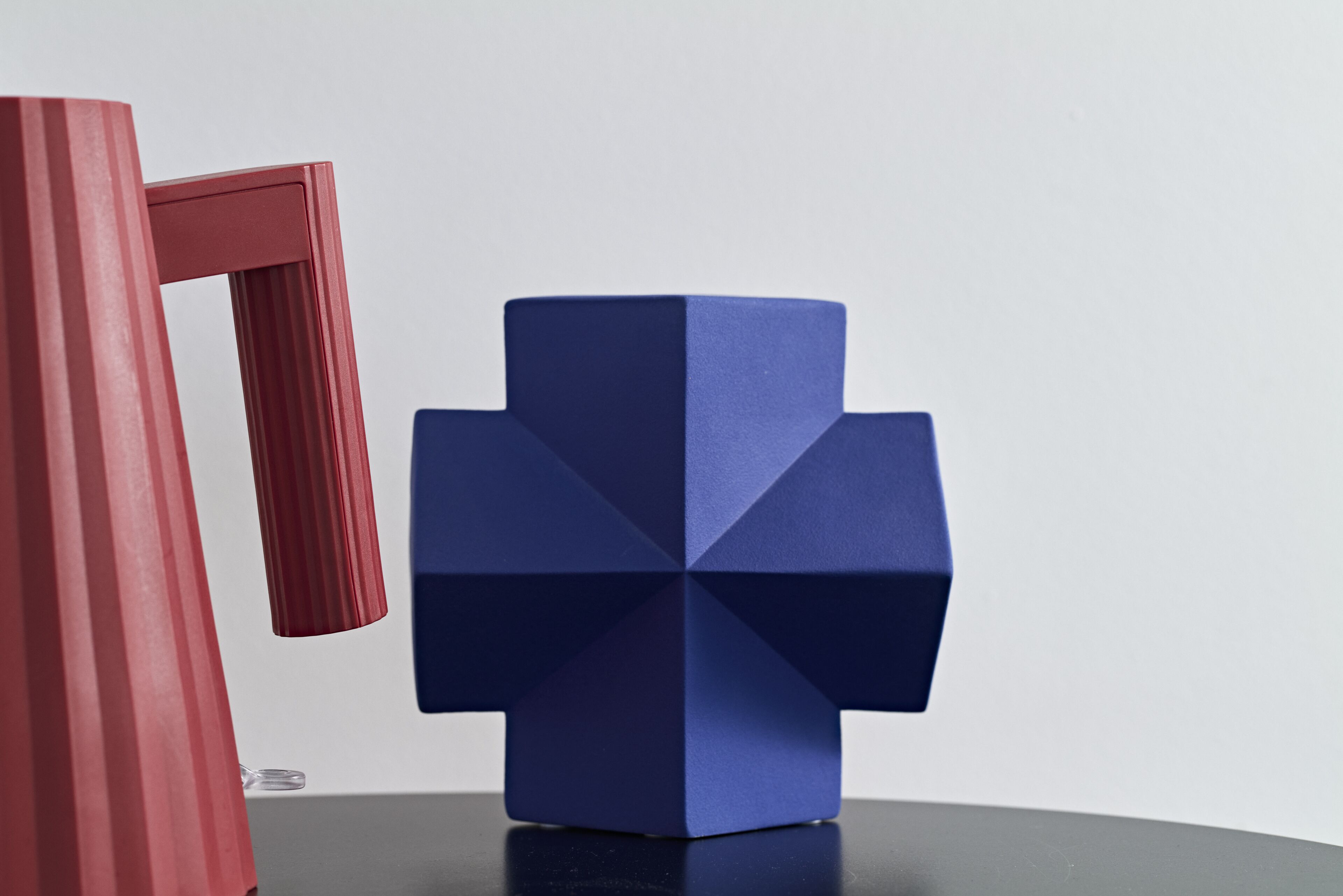 Une sculpture géométrique bleue, posée sur une table.