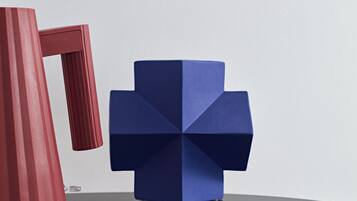 Une sculpture géométrique bleue, posée sur une table.