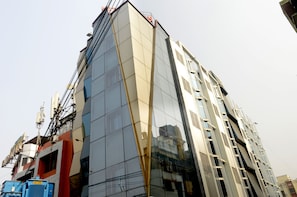 A modern building with a reflective glass facade and a prominent vertical gold stripe.