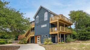 A two-story house with a balcony and a staircase leading to the second floor. - Climate Change - Duck, Sea Tern, Oceanside, 280 Yds to Beach, Pool, Hot Tub, Pets OK (Duck)