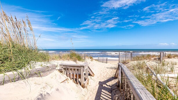 A sandy beach with wooden boardwalks and grassy dunes. - Climate Change - Duck, Sea Tern, Oceanside, 280 Yds to Beach, Pool, Hot Tub, Pets OK (Duck)