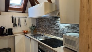 A kitchen with a stone backsplash, a built-in oven, and a toaster.