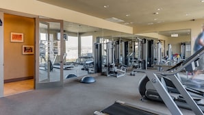 A gym with cardio equipment, weight machines, and mirrors on the walls.