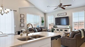 A modern kitchen with a central island, a built-in dishwasher, and a ceiling fan. - Spacious Villa 5 minutes to Lake State park by Redawning (Washington)