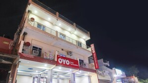Un edificio de dos pisos con un letrero que dice 'OYO Hotel Taj Paradise'.