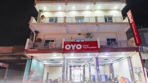 Un edificio de varios pisos con un llamativo letrero que dice 'OYO Hotel Taj Paradise'.