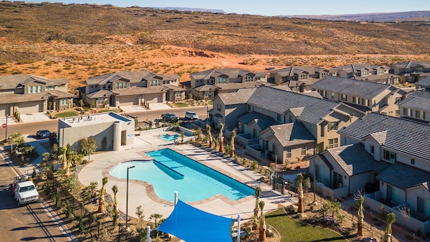 A residential area with modern houses, a swimming pool, and a desert landscape in the background. - Sunshine Serendipity 4 Bedroom Apts by RedAwning (Washington)