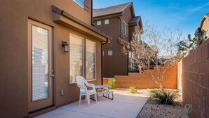 A residential building with a patio, a white chair, and a table. - Bike-on-inn 3 Bedroom Apts by RedAwning (Washington)
