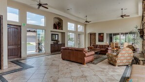 A spacious lobby with a brown leather sofa, a patterned armchair, and a stone fireplace. - Bike-on-inn 3 Bedroom Apts by RedAwning (Washington)