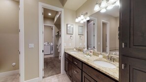 Une salle de bain moderne avec un meuble-lavabo à deux vasques, un grand miroir et une douche à l’italienne.