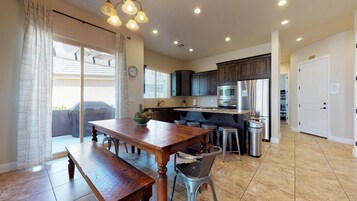 Una cocina moderna con armarios de madera oscura, electrodomésticos de acero inoxidable y una isla grande con taburetes.